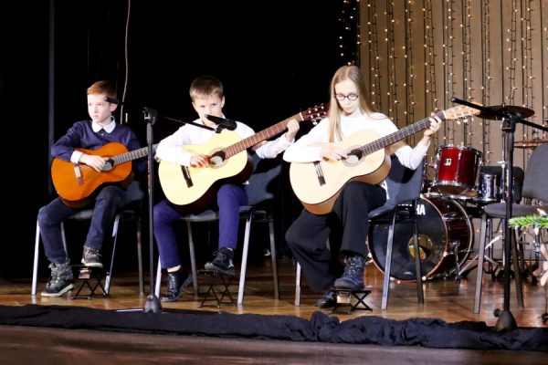 grupa młodzieży na scenie gra na gitarach