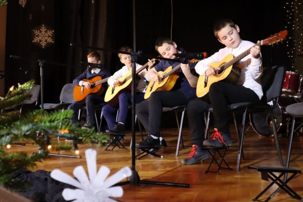 grupa młodzieży na scenie gra na gitarach