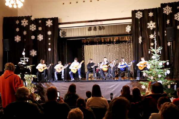grupa młodzieży na scenie gra na gitarach