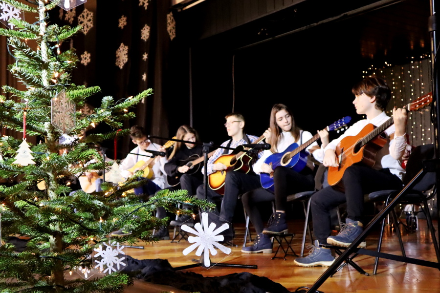 grupa młodzieży na scenie gra na gitarach