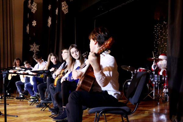 grupa młodzieży na scenie gra na gitarach