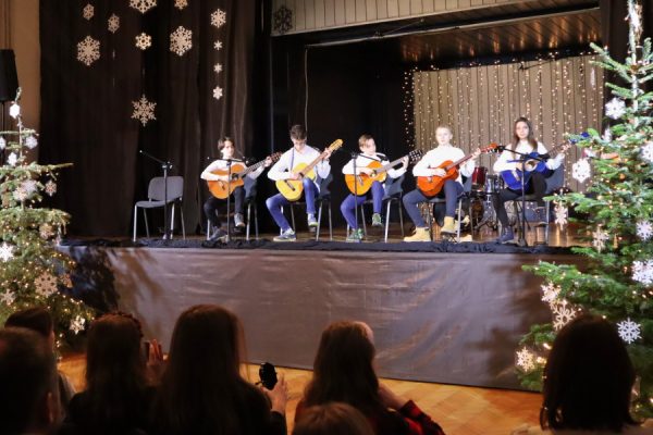 grupa młodzieży na scenie gra na gitarach