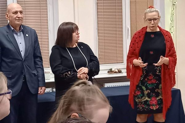 trzy osoby, jedna z nich mówiąc gestykuluje