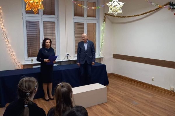 mężczyzna i kobieta stoją przed stołem, kobieta przemiawia