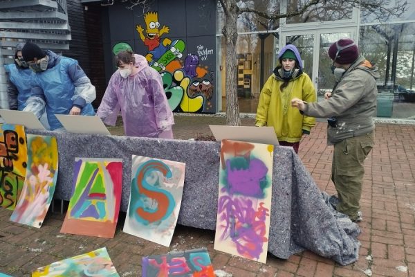 grupa młodzieży w trakcie warsztatów grafiitti