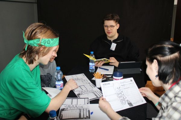 grupa młodzieży siedzi przy stole