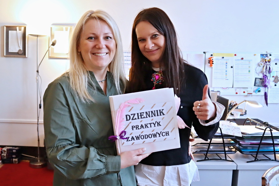dwie kobiety trzymają w rękach książke z napisem dziennik praktyk zawodowych