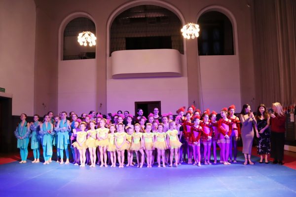 grupa dziewcząt tancerek w kolorowych strojach pozuje do zdjęcia