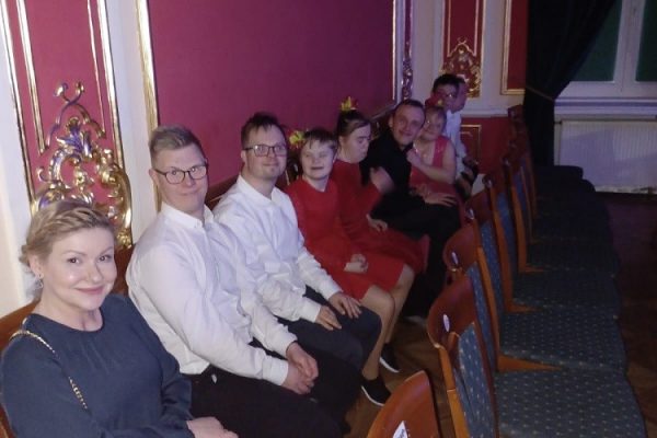 grupa uczestników wraz z nauczycielką siedzi na krzesłach