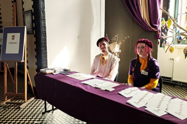 chłopak i dziewczyna siedzą w dziekanacie na stole indeksy