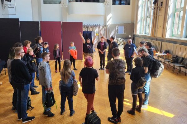 grupa młodzieży stoi na środku auli