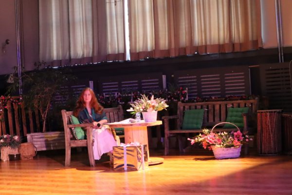 kobieta siedzi przy stoliku wokół scenografia widowiska