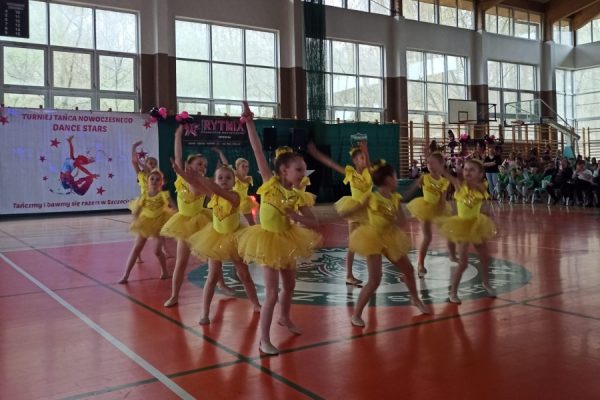 grupa dziewcząt w żółtych strojach w trakcie tańca