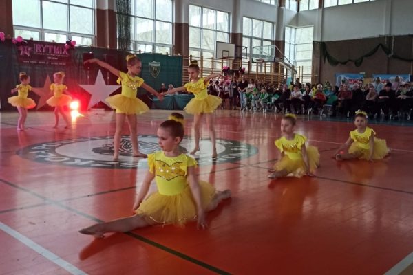 grupa dziewcząt w żółtych strojach w trakcie tańca