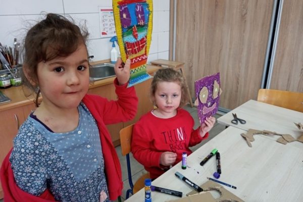 dziewczynki trzymają w rękach swoje prace