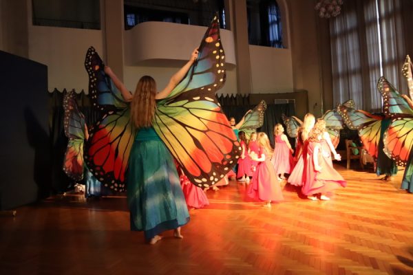 Kobiety w kolorowych strojach w tańcu ze skrzydłami motyla