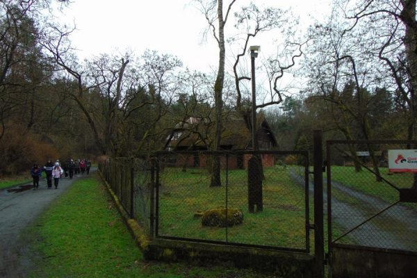stare zabudowania leśniczówki Owczary, drogą idzie młodzież