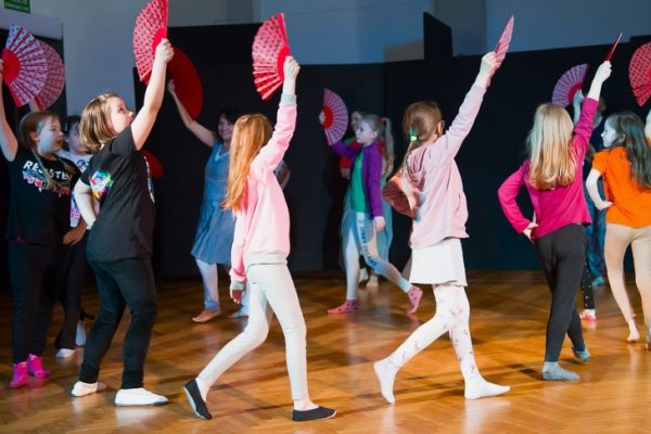 dziewczęta w trakcie tańca w rękach wachlarze