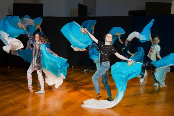 dziewczęta w trakcie tańca w rękach wachlarzowoale