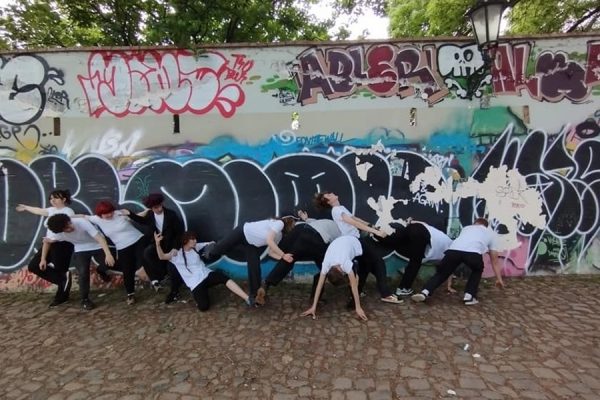 grupa młodzieży przed muralem