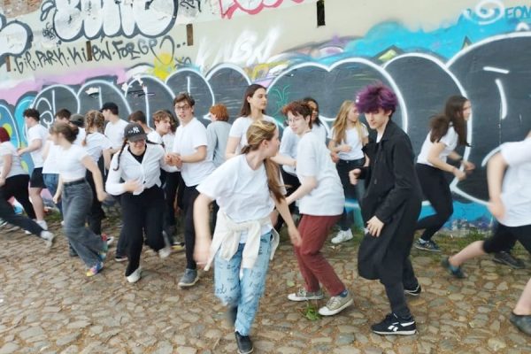 grupa młodzieży przed muralem