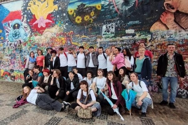 grupa młodzieży pozuje do zdjęcia na tel Muru Lenona