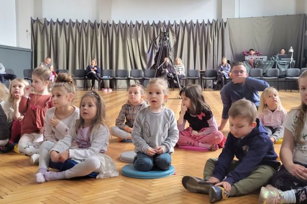 grupa dzieci siedzi na podłodze