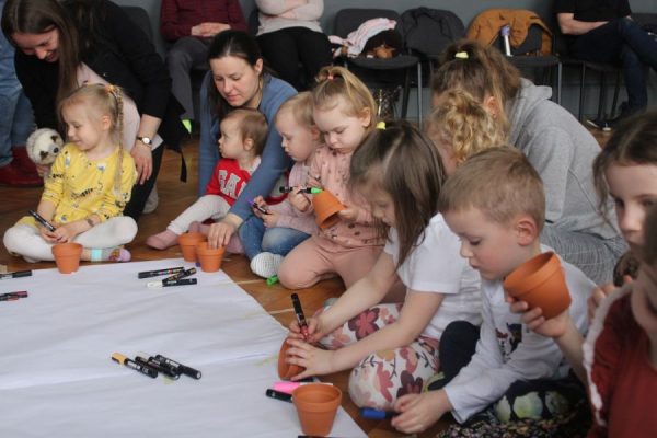 grupa dzieci w trakcie spotkania sadzi nasionka