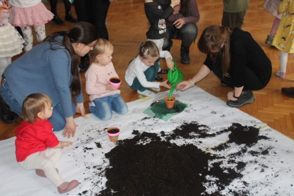 grupa dzieci w trakcie spotkania sadzi nasionka