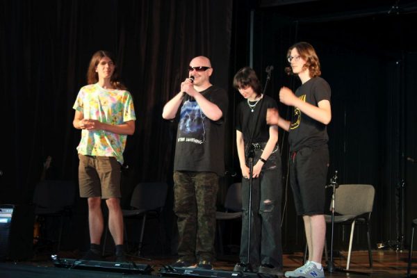 grupa młodzieży z nauczycielem na scenie