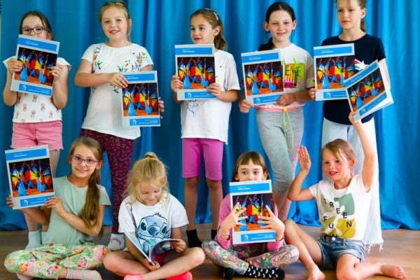 Dziewczynki pozują do zdjęcia z książkami