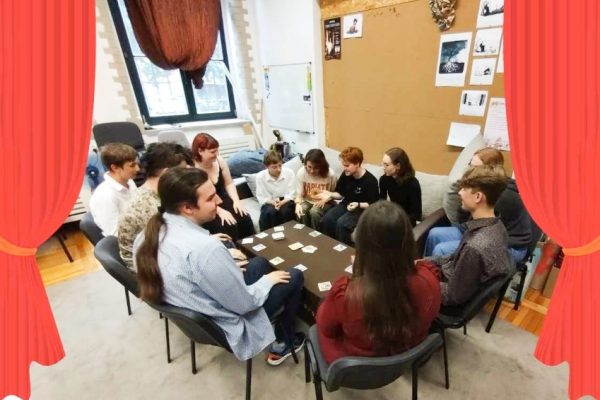 grupa młodzieży siedzi przy stole