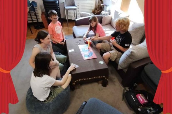 grupa młodzieży siedzi przy stole podczas gry