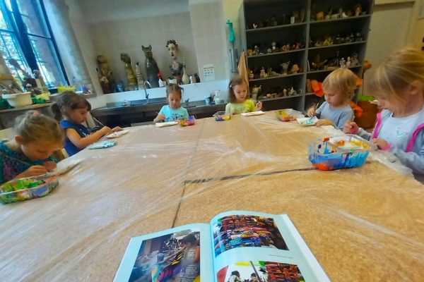 dzieci w trakcie warsztatów siedzą przy stole