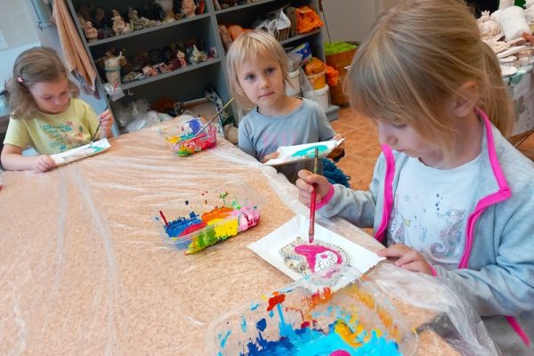 dzieci w trakcie warsztatów siedzą przy stole malują