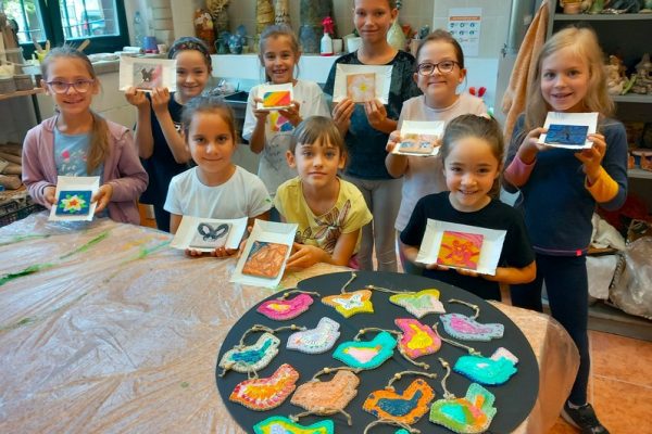 dzieci w trakcie warsztatów siedzą przy stole tworząc prace