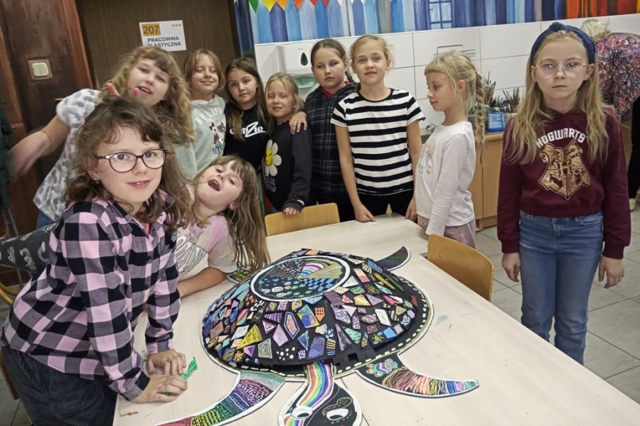 dzieci w pracowni stoja przy swoje pracy