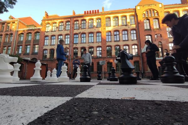 uczestnicy zajęć grają w szachy na boisku