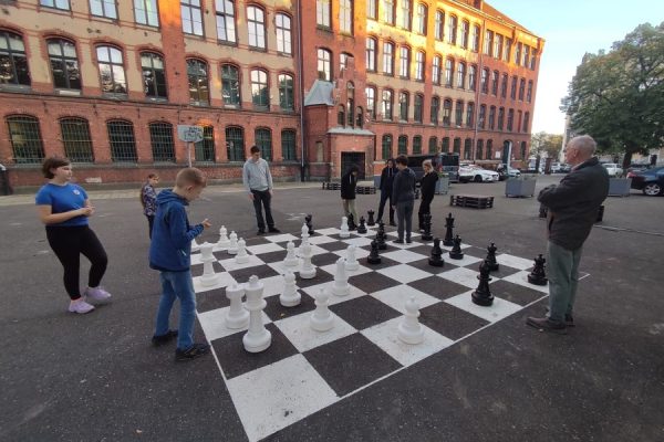 uczestnicy zajęć grają w szachy na boisku