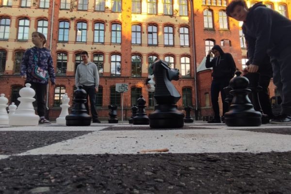 uczestnicy zajęć grają w szachy na boisku