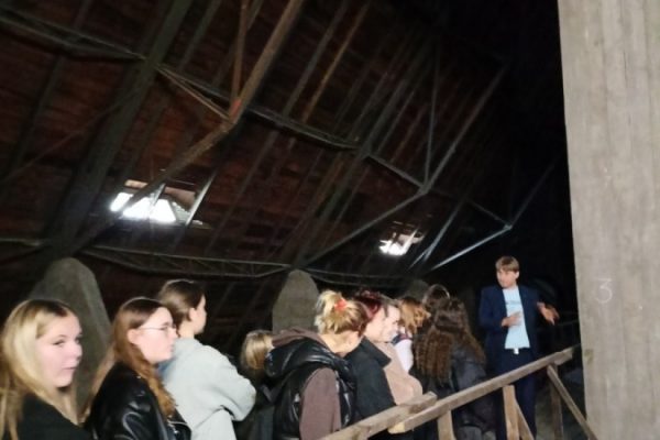 grupa młodzieży z przewodnikiem zwiedza katedrę