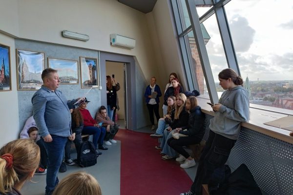 grupa młodzieży z przewodnikiem zwiedza katedrę