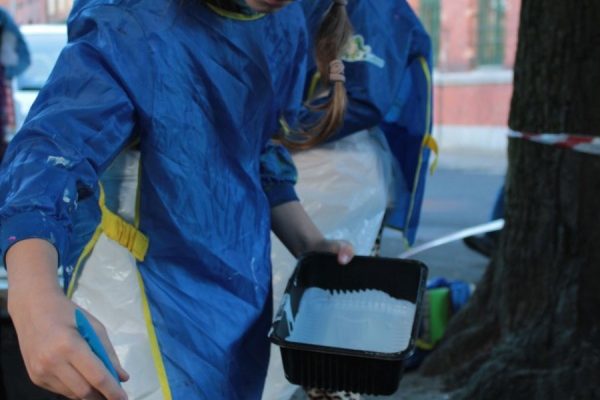 dziewczynka w trakcie malowania ławki