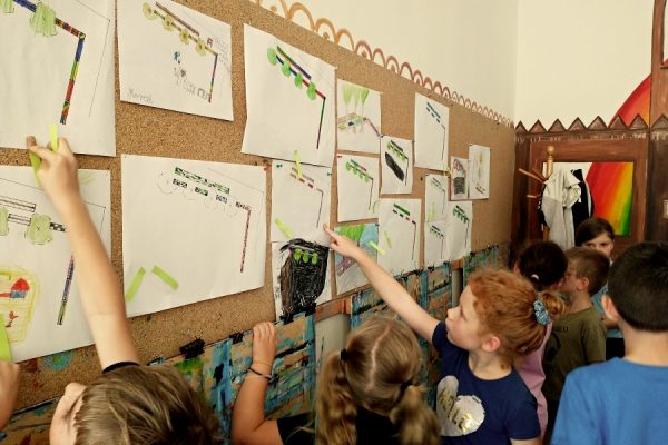 grupa dzieci przy tablicy korkowej