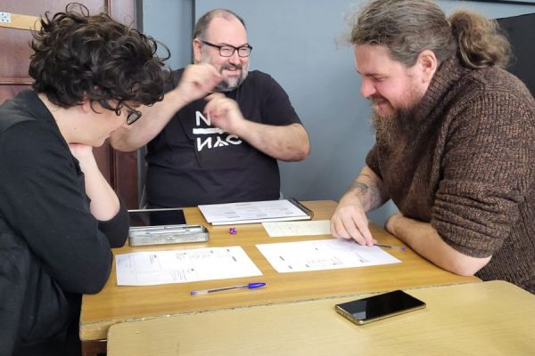 grupa uczestników przy stole podczas gry