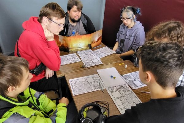 grupa uczestników przy stole podczas gry