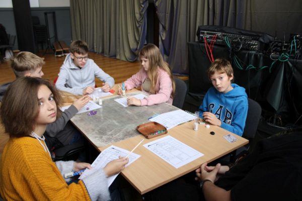 grupa uczestników przy stole podczas gry