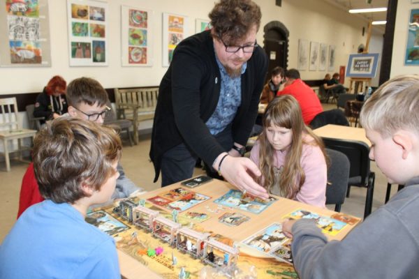 grupa uczestników przy stole podczas gry