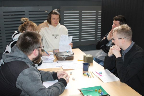 grupa uczestników przy stole podczas gry