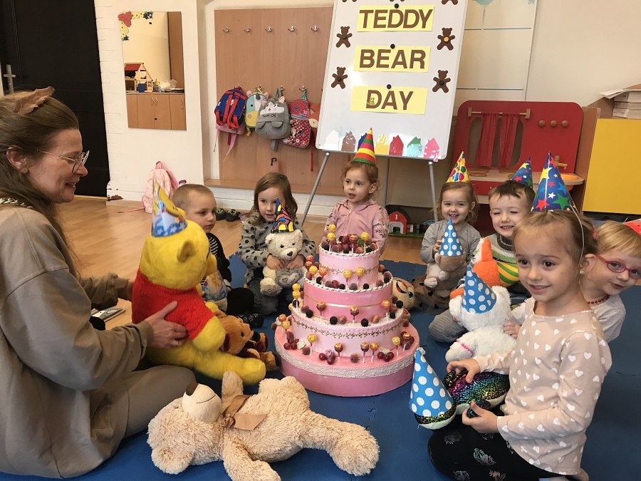 grupa dzieci siedzi na podłodze wokół tortu